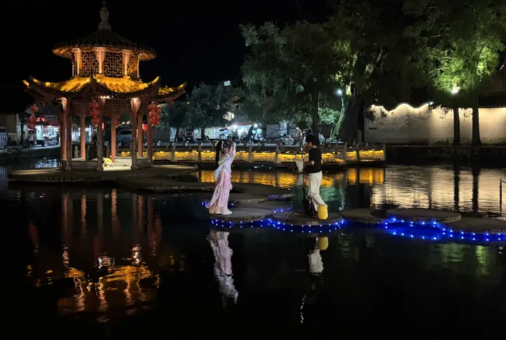 游客在鲤鱼溪夜景中沉浸式“旅拍”。龚键荣摄