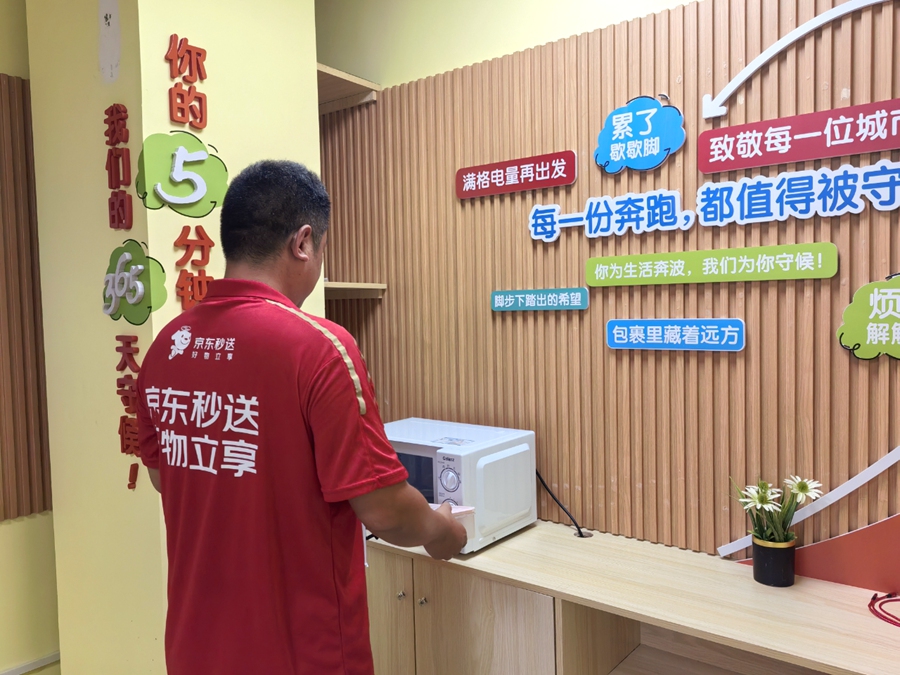 一名快遞員在“新鄰驛站”內歇息、充電。思明區委社會工作部供圖