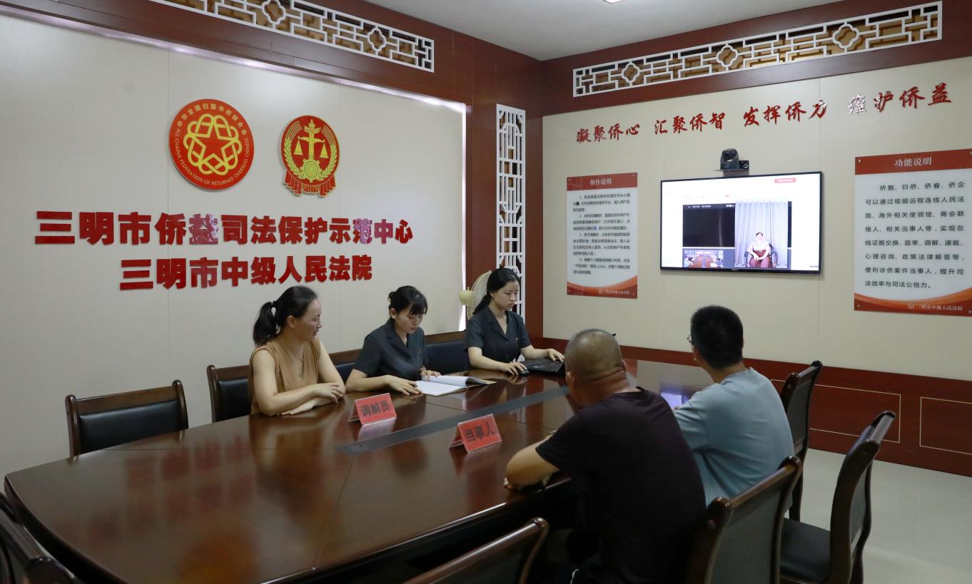村干部戴清華（左一）在市僑益司法保護中心運用遠程視頻調解涉僑民事案件。