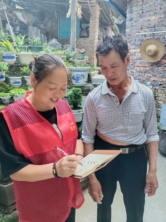 凤埔乡峦龙村党支部书记周丽玲入户记录群众需求。周东海摄