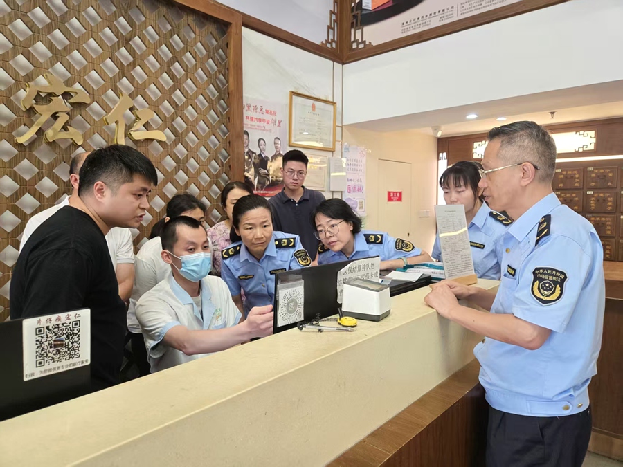 药品检查技能大比武实战现场，三名市场监管执法人员细致检查辖区一家药店执业药师胸牌佩戴、药品储存避光、冷藏记录完整、处方药销售规范等情况。湖里市场监管局供图