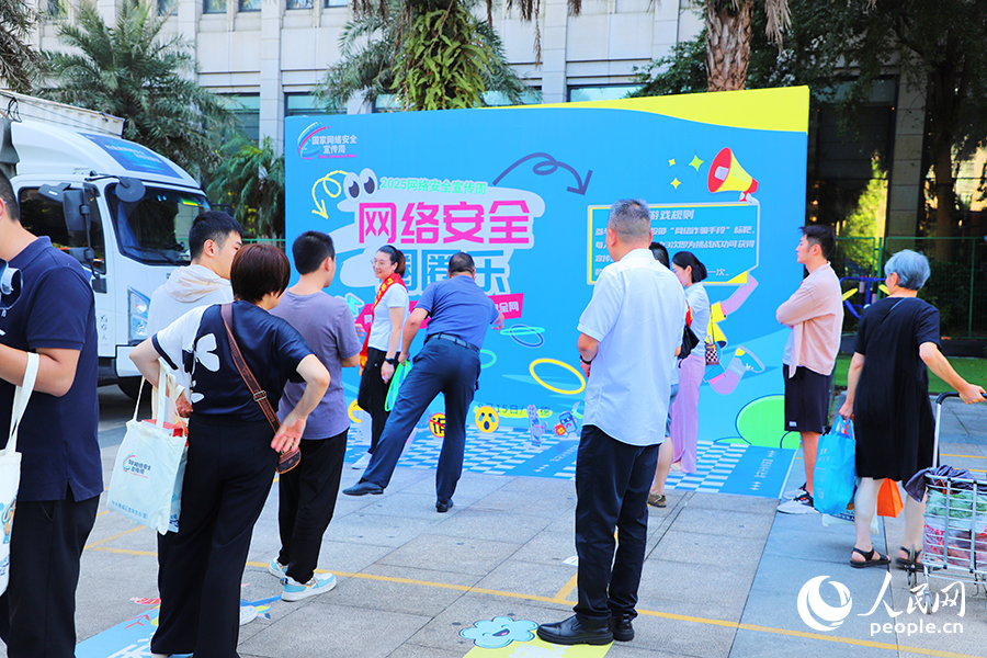 市民在“網絡安全進社區”活動現場排隊體驗網絡安全科普小游戲。人民網 黃東儀攝
