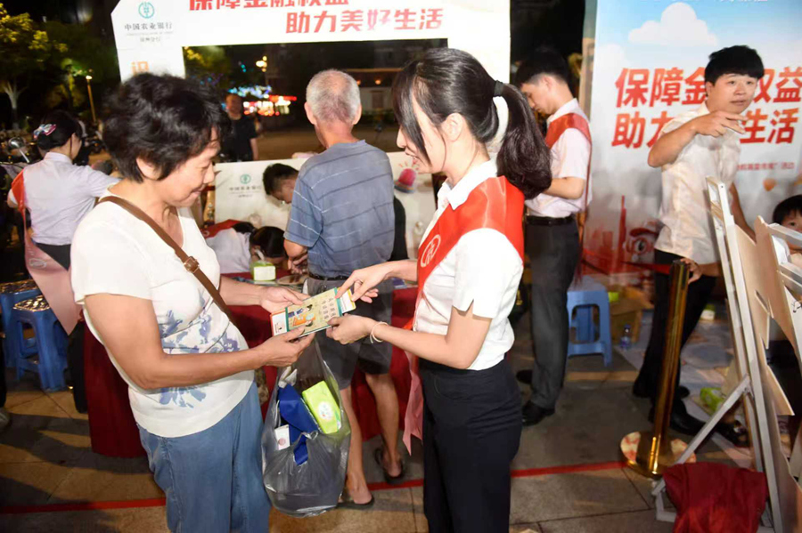 農行漳州分行工作人員向市民發放宣傳折頁和漫畫手冊。蔡淇斌攝