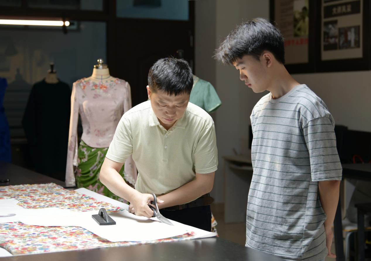 封衛平與學生設計服裝版型。