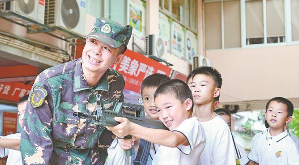 老兵在指導小營員進行射擊體驗。
