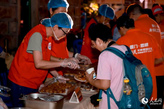 现场邀请“文明合伙人”——新市民品尝在地老味道。人民网记者 陈博摄