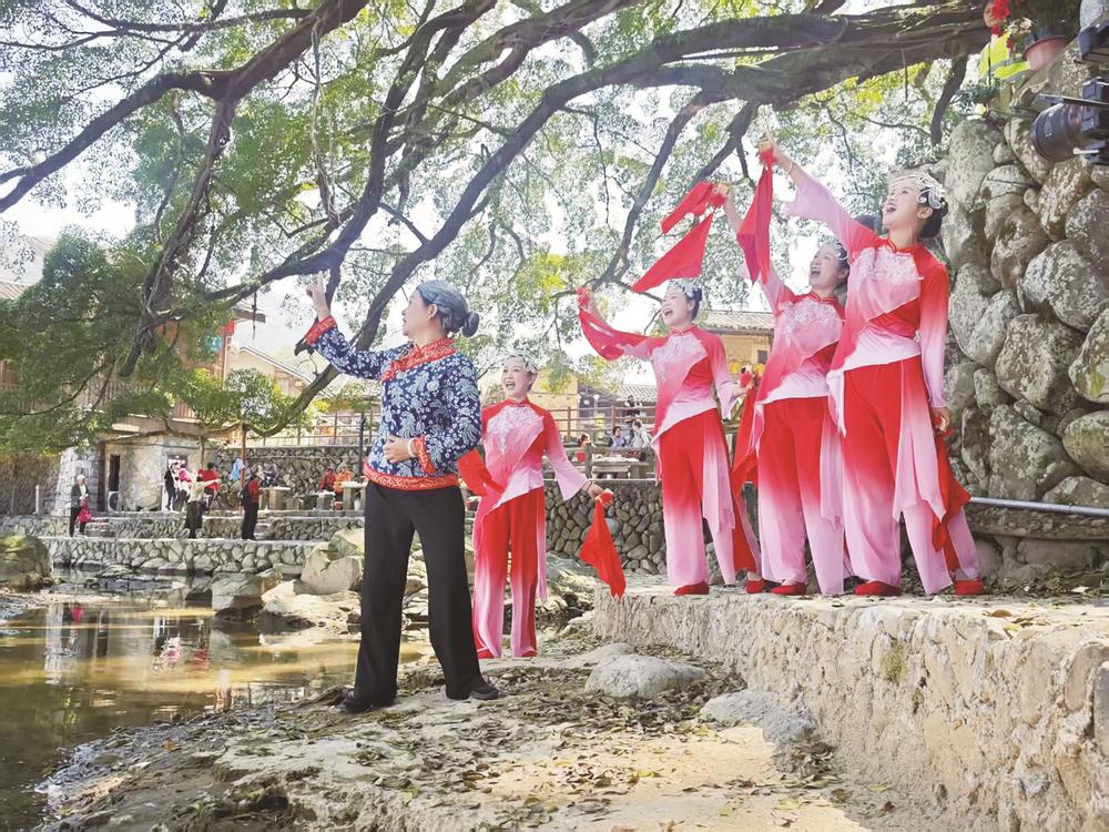 “土樓紅妹子”在南靖雲水謠景區用快板表演《土樓人民笑開顏》。
