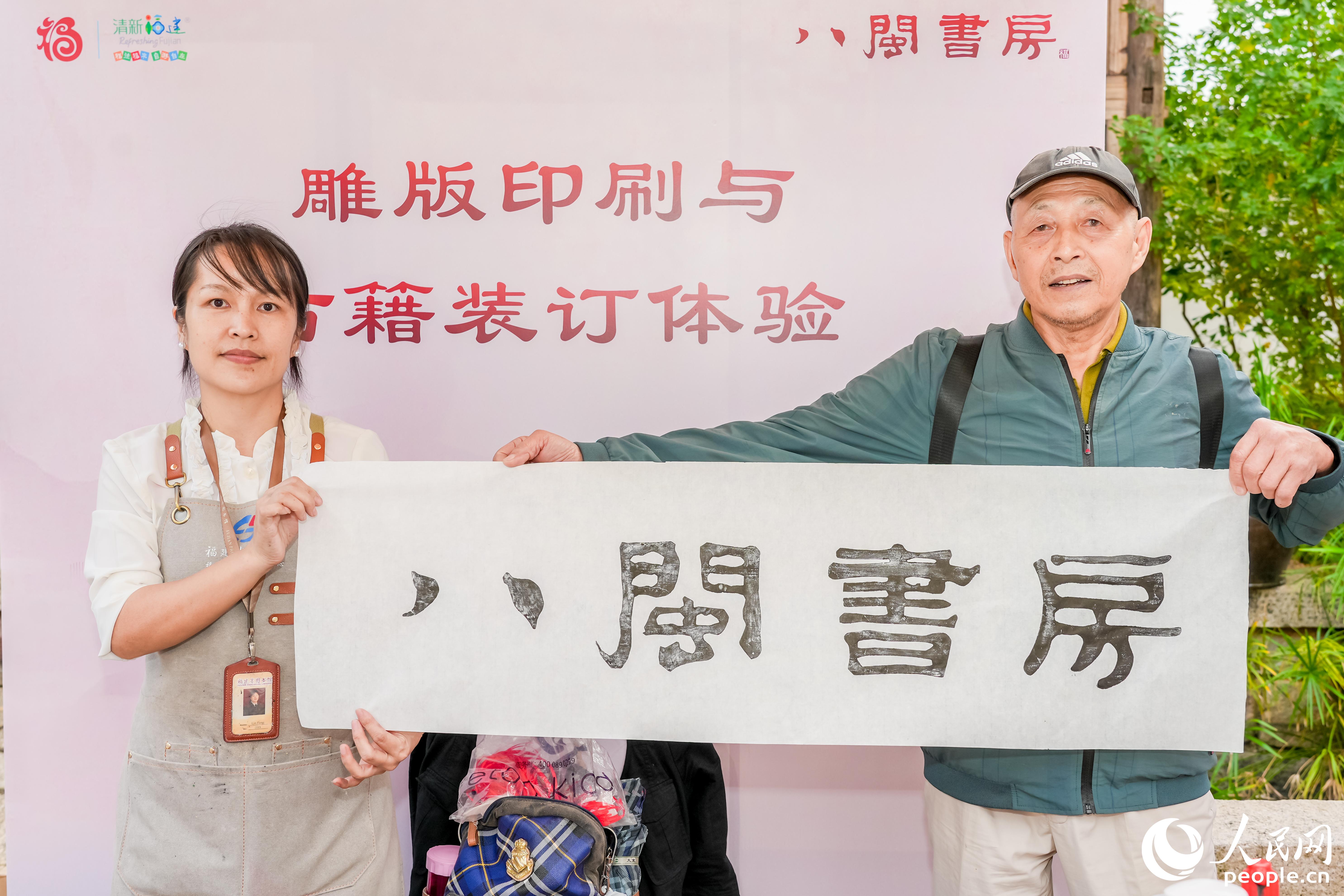 一位市民展示自己在“八閩書房”書香市集體驗雕版印刷的成果。人民網攝