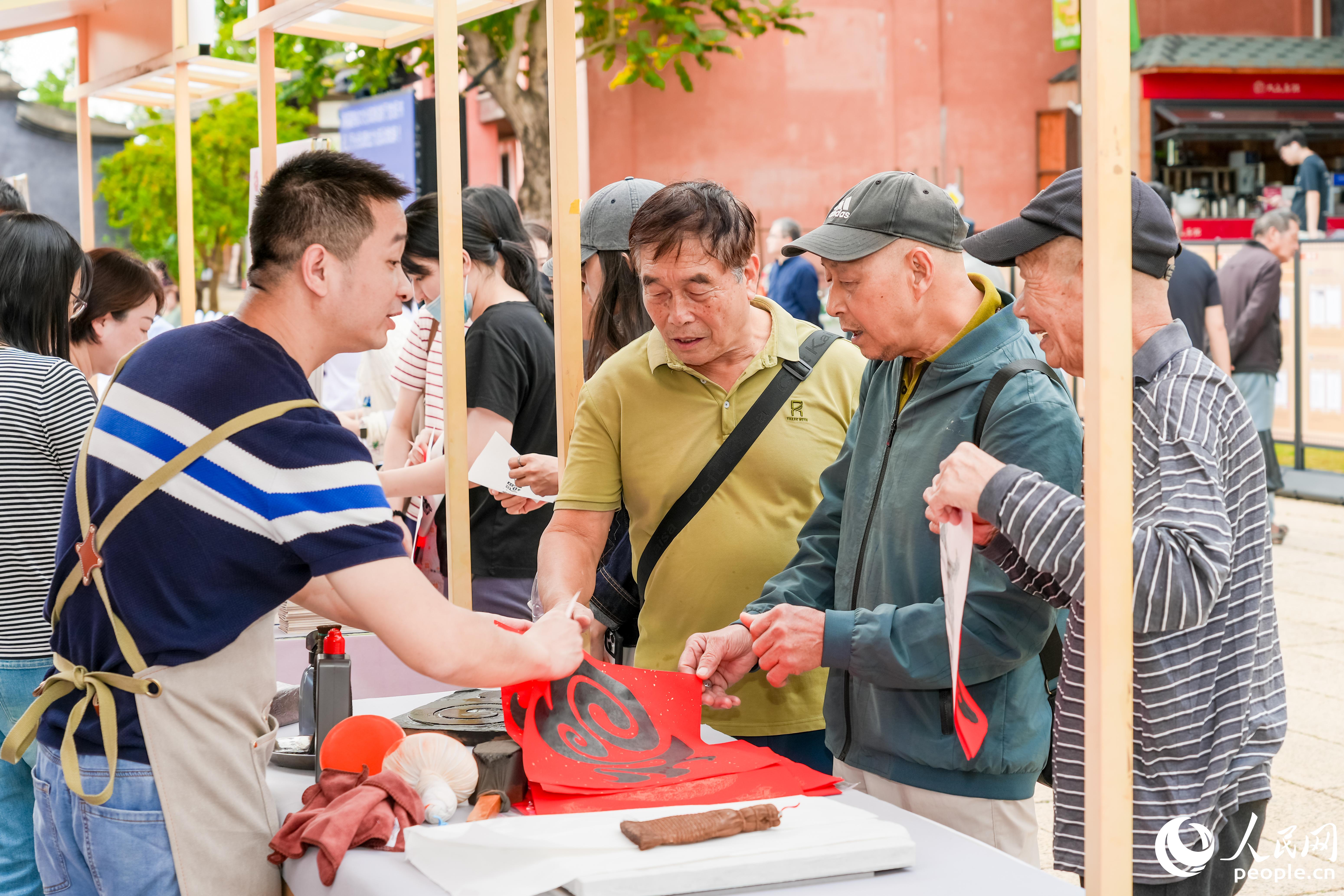 市民在“八閩書房”書香市集體驗雕版印刷。人民網攝