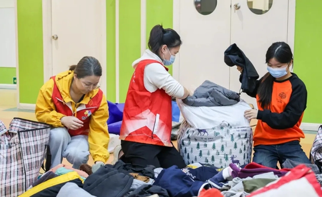 志愿者对衣物进行分类整理打包