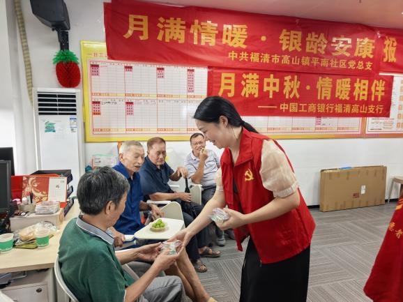 高山鎮平南社區黨員志願者為轄區老人遞上手工制作的月餅。高山鎮供圖