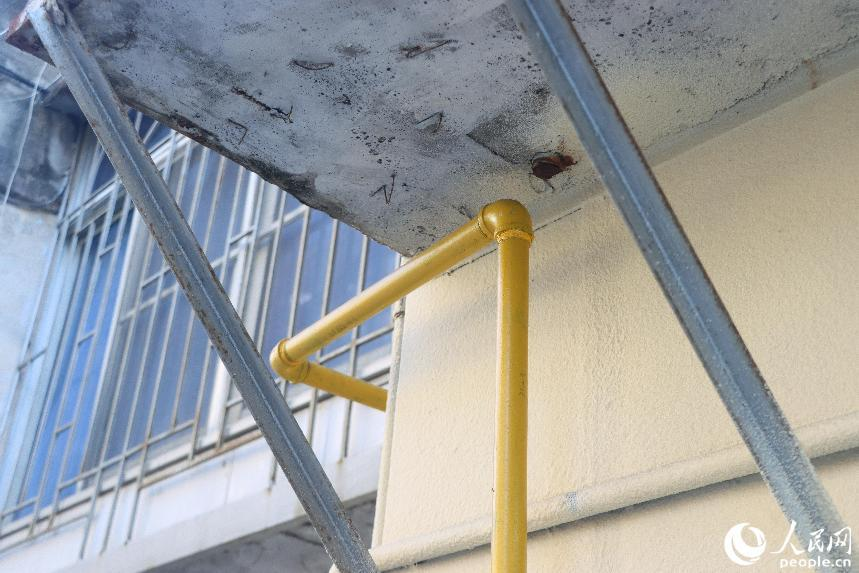 黃色的新管道與曾經從戶內穿過的舊管道痕跡。人民網 林銘賢攝