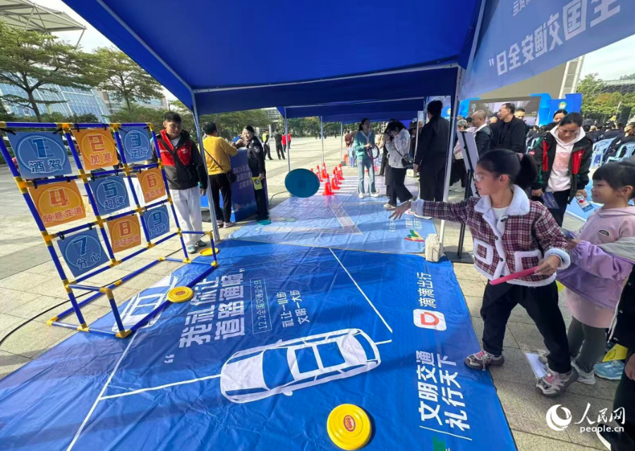 交通安全游戏互动区,小朋友正在投掷飞盘。人民网记者 张萌摄