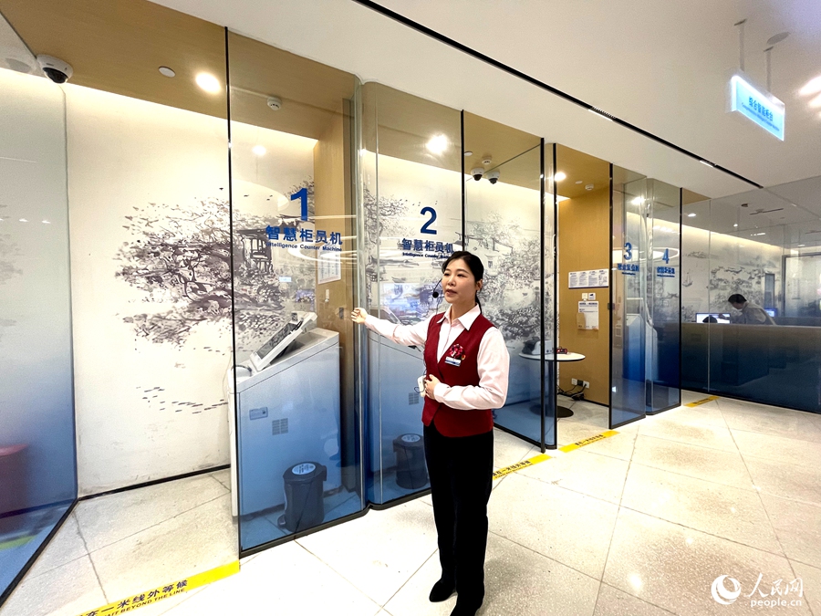 興業銀行西湖支行現場工作人員介紹網點智慧櫃員機。人民網記者 陳藍燕攝