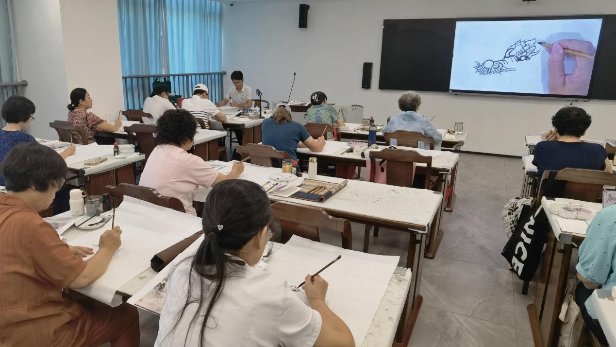 国画花鸟班学员通过指法摄像头和电子屏，可实时观摩老师的笔法运用细节。
