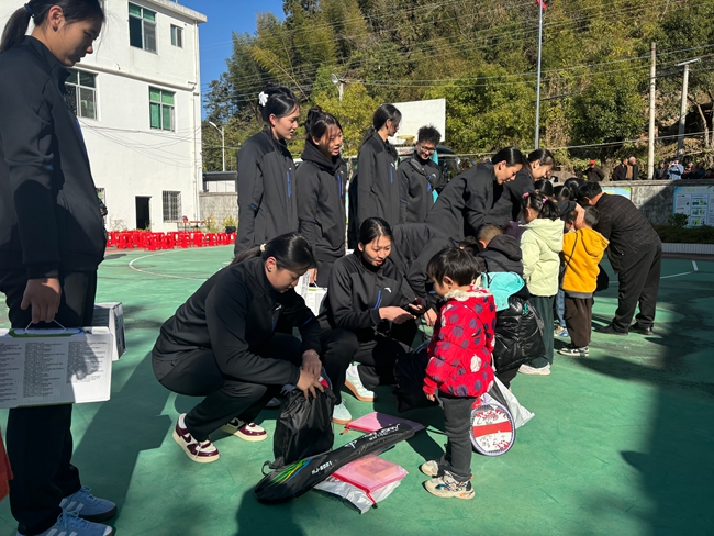 女排队员们为学生们送上了书包、文具、牛奶等慰问品