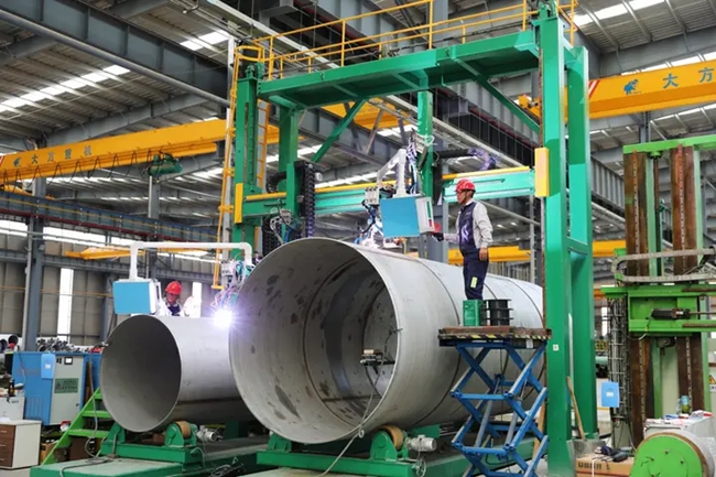 在青山钢管厂房内,工人正在有序生产作业。汤文娟摄