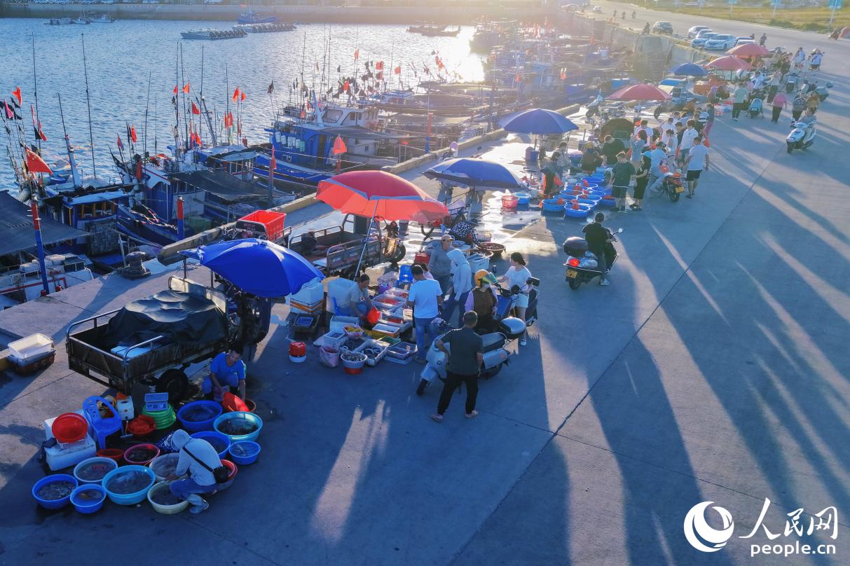 渔船靠岸，渔民们开始叫卖渔获。人民网记者 李唯一摄