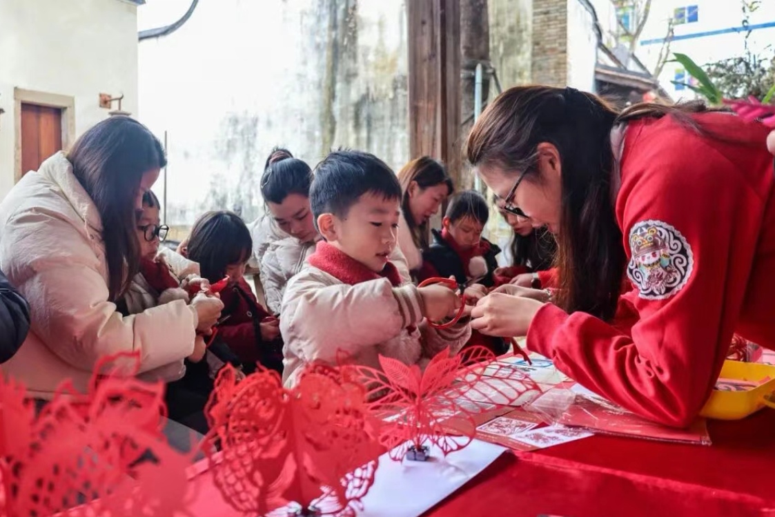 家長與孩子們在體驗剪紙項目