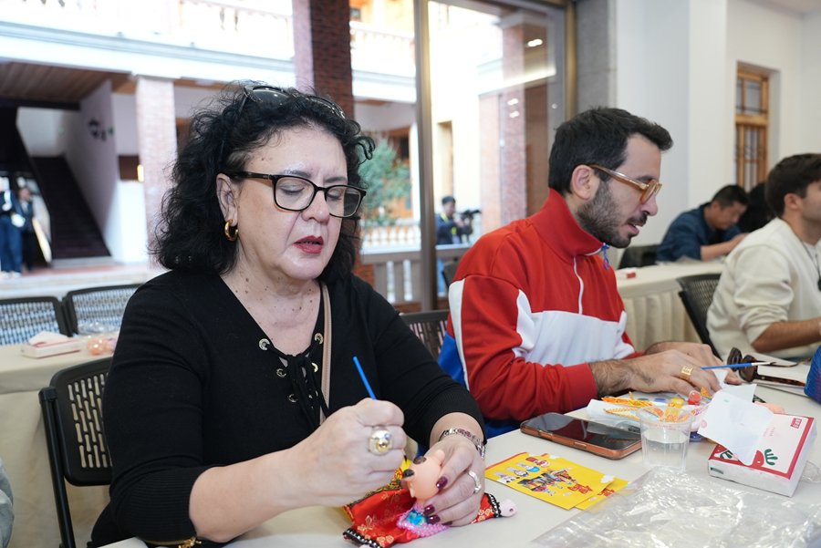 来宾亲身体验木偶粉彩技艺。卢臻摄