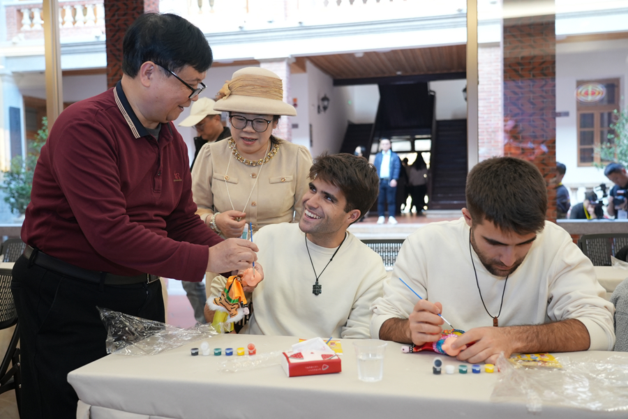 非遗代表性传承人现场亲授技艺,来宾执笔为木偶赋彩。卢臻摄