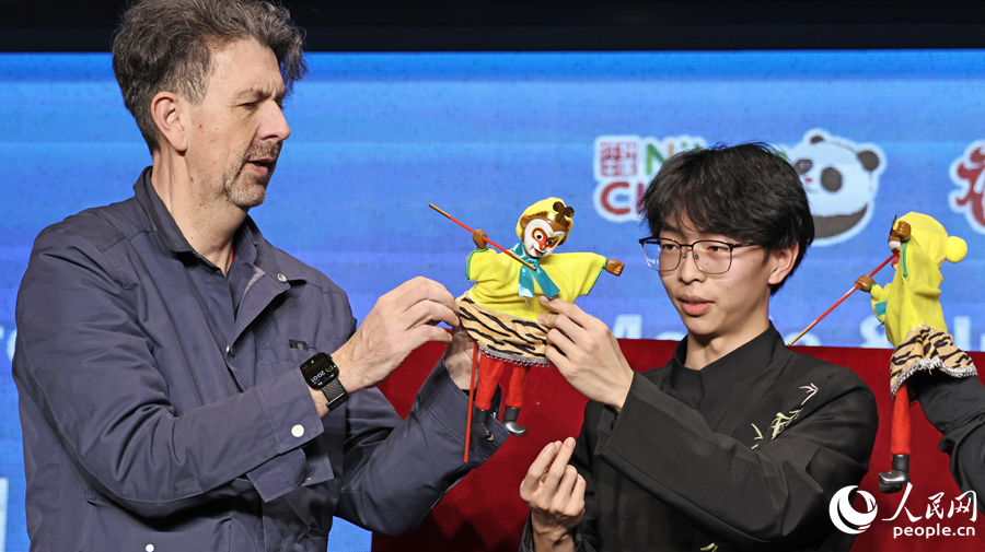 来宾体验体现布袋木偶。人民网记者 李昌乾摄