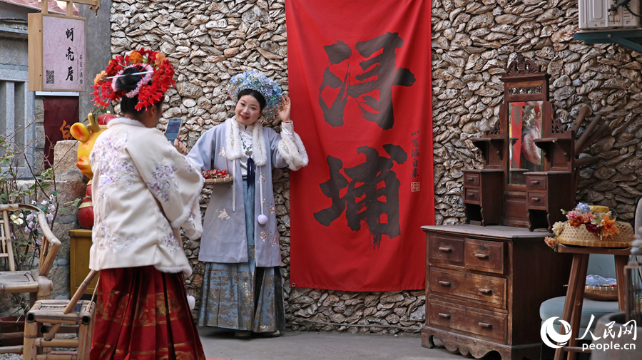 身着汉服，头戴簪花围的游客打卡拍照。人民网记者 李昌乾摄