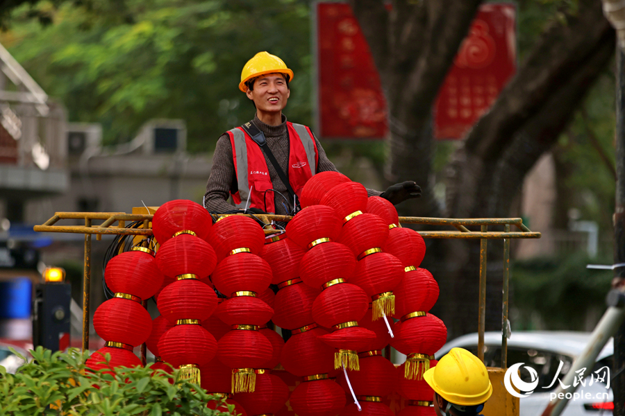 工人將成串燈籠挂上升降機。人民網記者 陳博攝