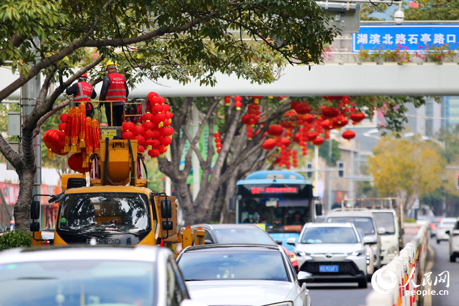 工人們在車流中登高作業挂燈籠。人民網記者 陳博攝