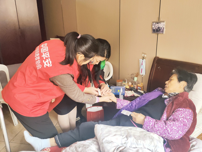 平安产险莆田中心支公司志愿者为老人测量血压，建立专属健康档案