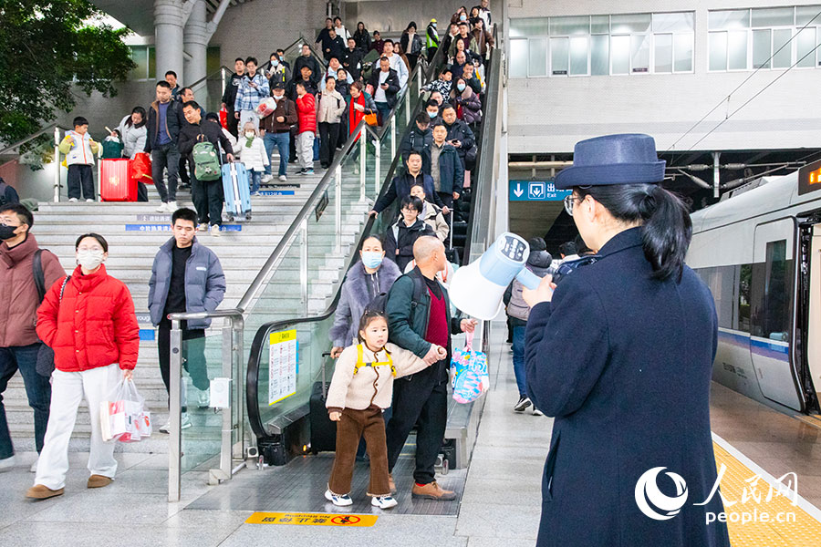 福州火车站客运工作人员引导旅客有序上车。人民网记者 焦艳摄