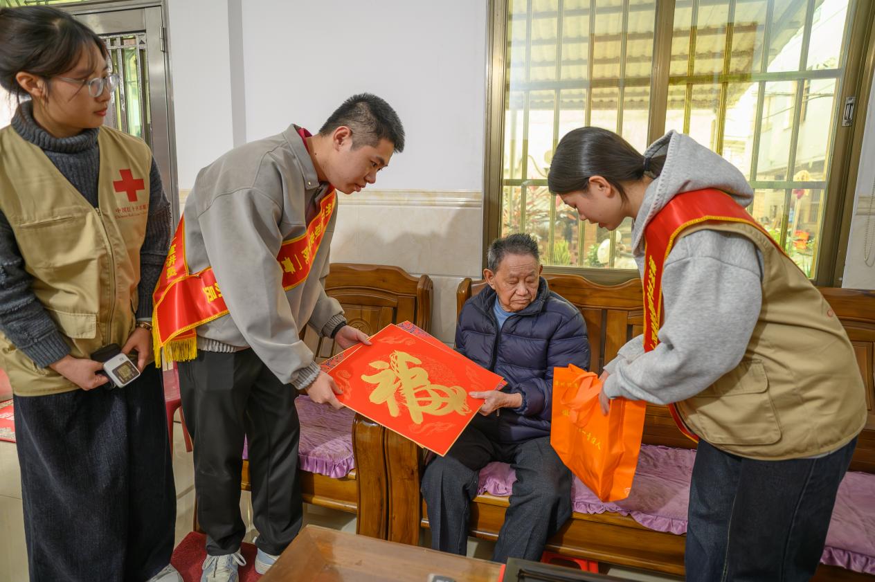 队员们将寓意吉祥的“福”字与健康关怀一并送到群众手中