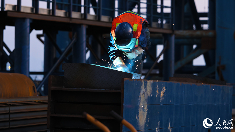 建設者正在專注施焊，為跨海工程筑牢根基，現場焊花四濺。人民網記者 李昌乾攝