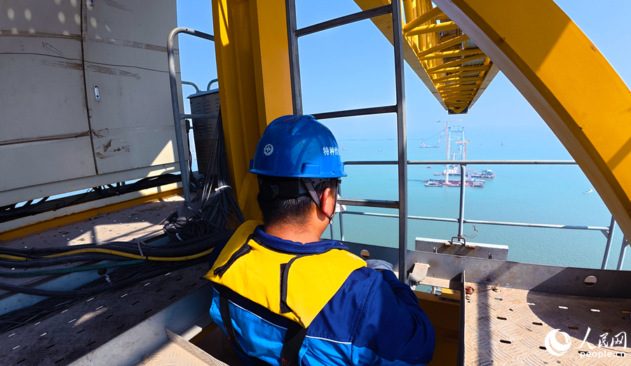 塔吊司機沿爬梯攀爬至200米高空駕駛室，在“雲端”建大橋。人民網記者 李昌乾攝