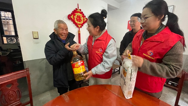 福满社区党委书记黄婷婷和志愿者带着米和食用油上门探访独居老人