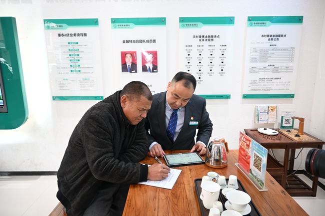 李文慰在“惠农服务旗舰店”暨“李文慰劳模工作室”为农户办理业务