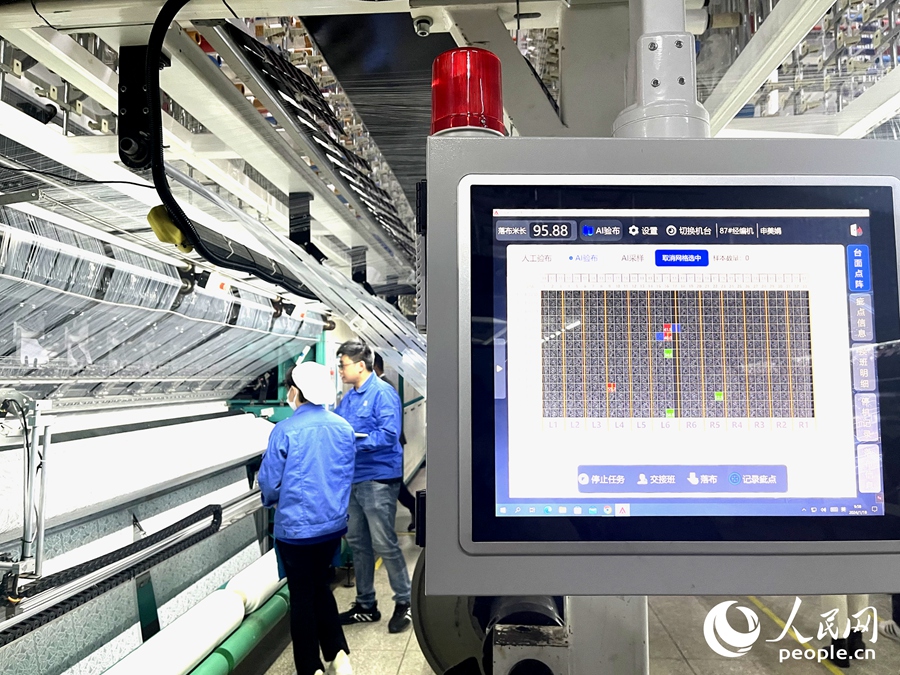 AI智能檢測系統正在檢測東龍針紡坯布上的瑕疵。人民網記者 陳藍燕攝