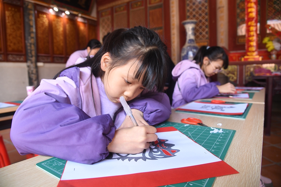 在泉港區后龍鎮涂坑古民居劉氏宗祠內，孩子們正在進行年畫剪紙體驗
