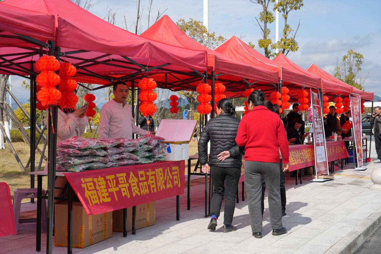 周边市民在摊位前选购商品。谢思棋摄