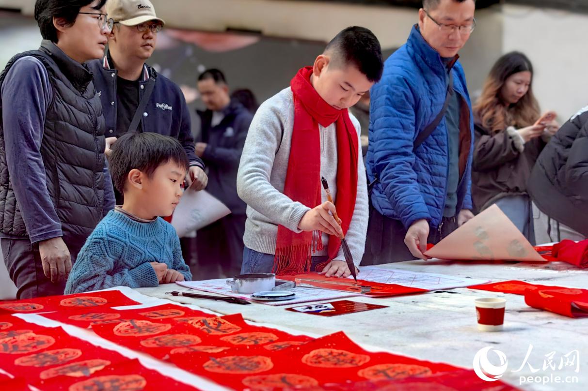 小朋友一筆一畫專注書寫，引人圍觀。人民網記者 葉青卿攝