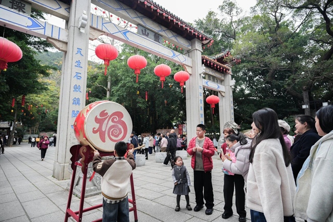 游客敲響“迎春鼓”