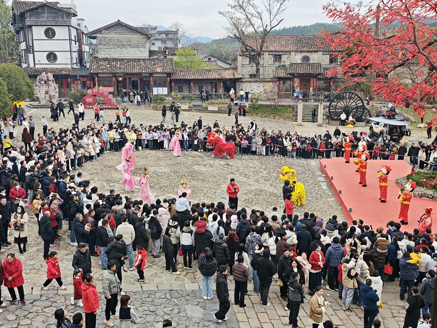 和平古镇谯楼前许多游客观看“财神爷”表演