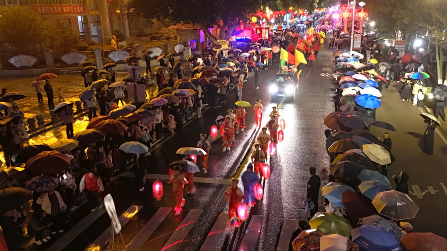 市民游客在雨中观看巡游