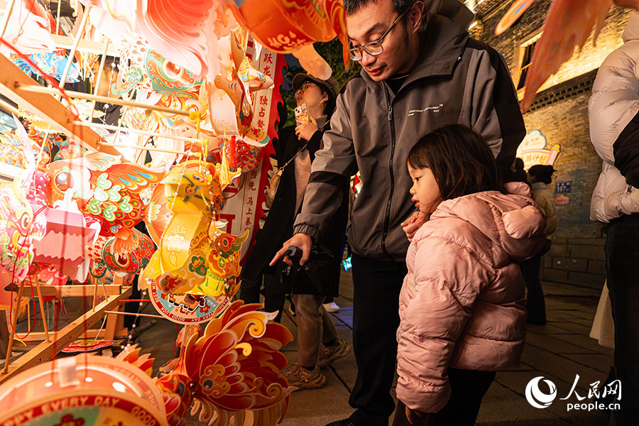 家长带着孩子选购手提花灯。实习生 李雨泽摄