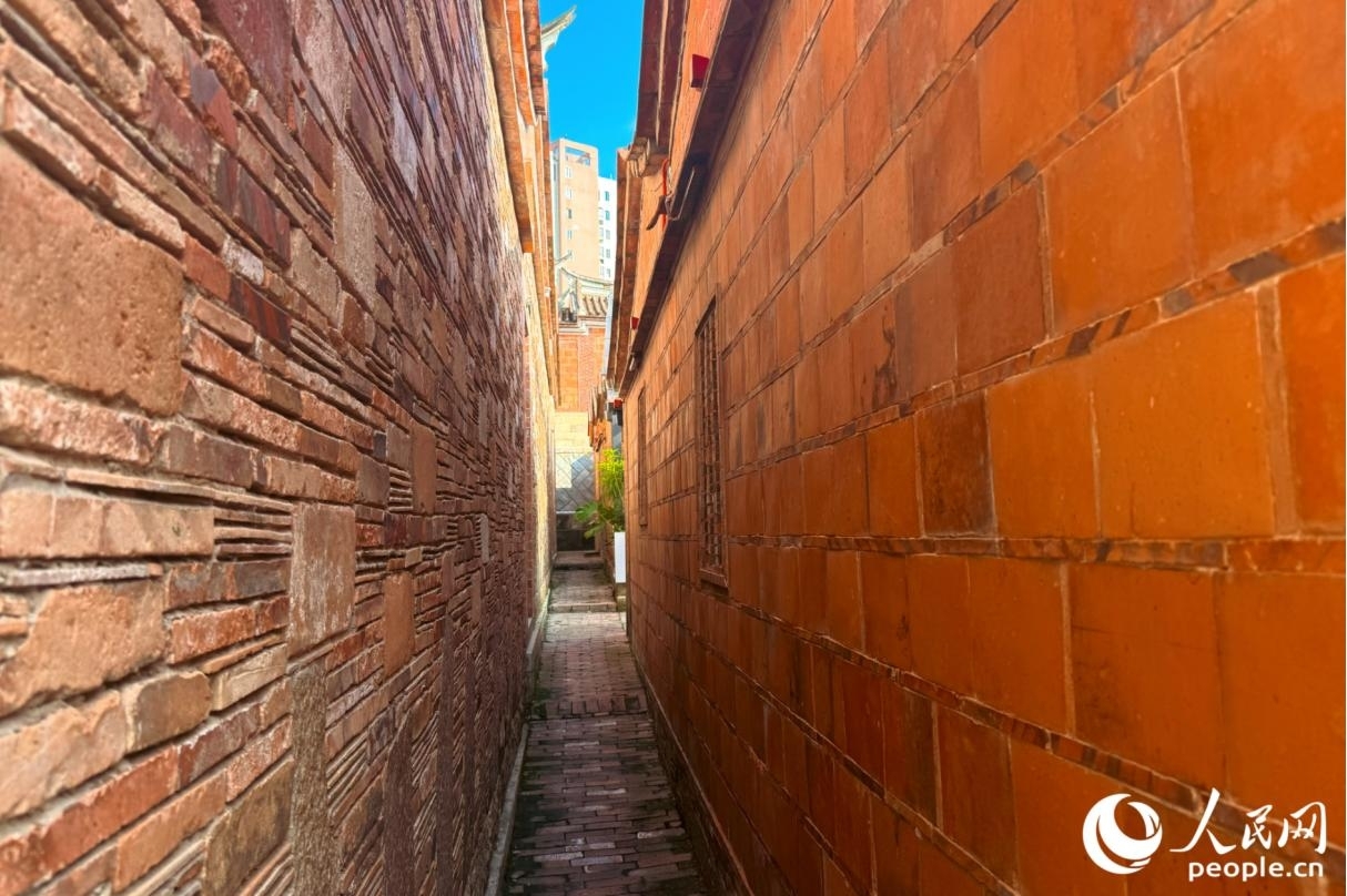 形状各异的石材与规整统一的红砖交垒叠砌,呈现出红砖古厝独特的肌理美感。人民网记者 李唯一摄