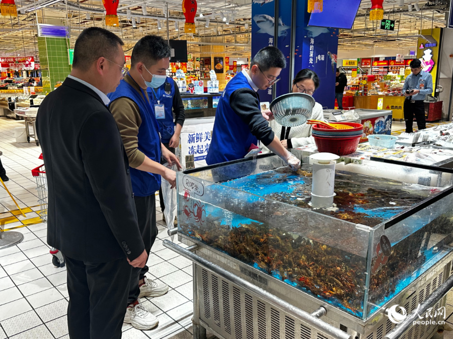“抽样团”对水产品进行抽检。人民网记者 张萌摄