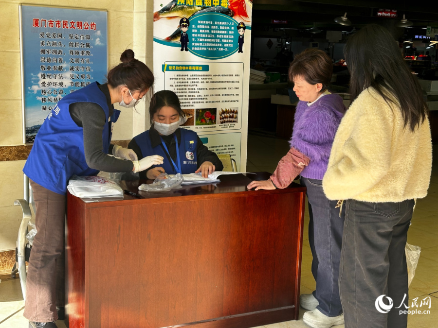 “你送我检”环节，市民排队进行登记送检食材。人民网记者 张萌摄