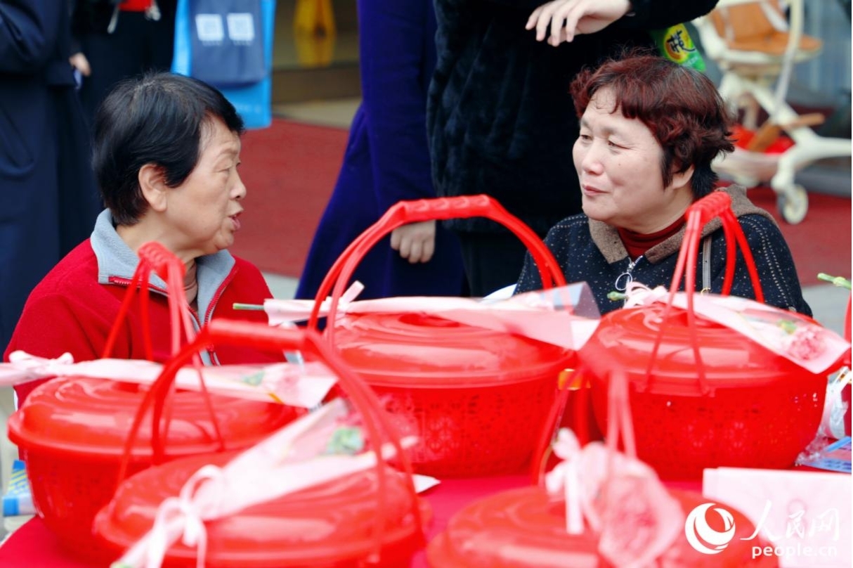 市民在领取节日赠品后寒暄。人民网记者 李唯一摄