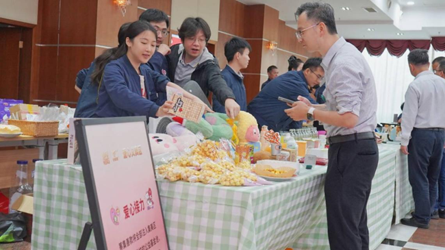 职工在义卖摊位前选购爱心商品