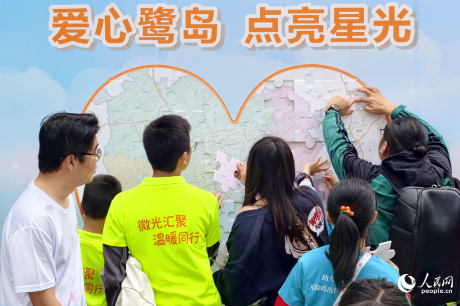 孩子們在志願者幫助下完成愛心拼圖。人民網記者 陳博攝
